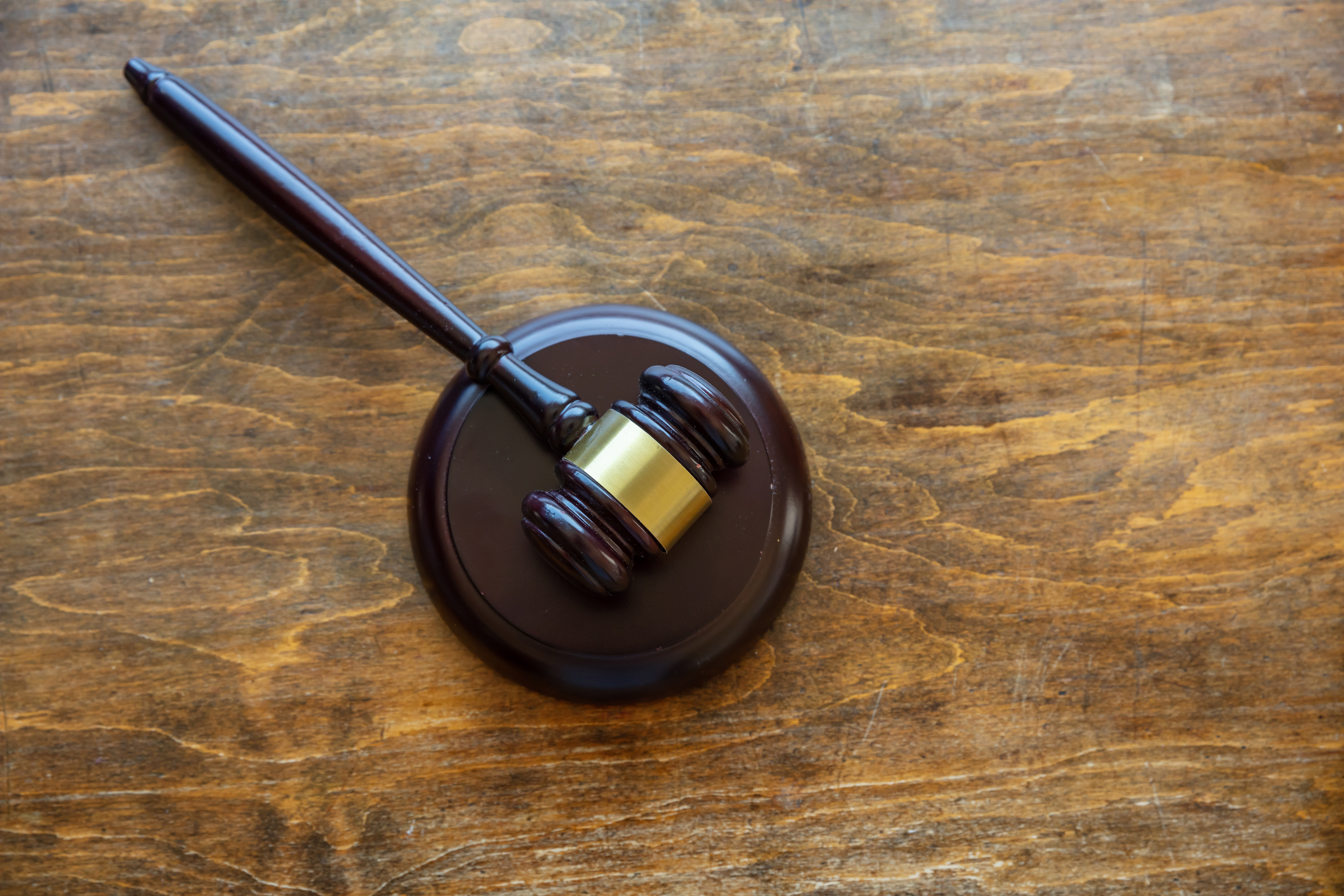 A judge's gavel resting on a wooden desk