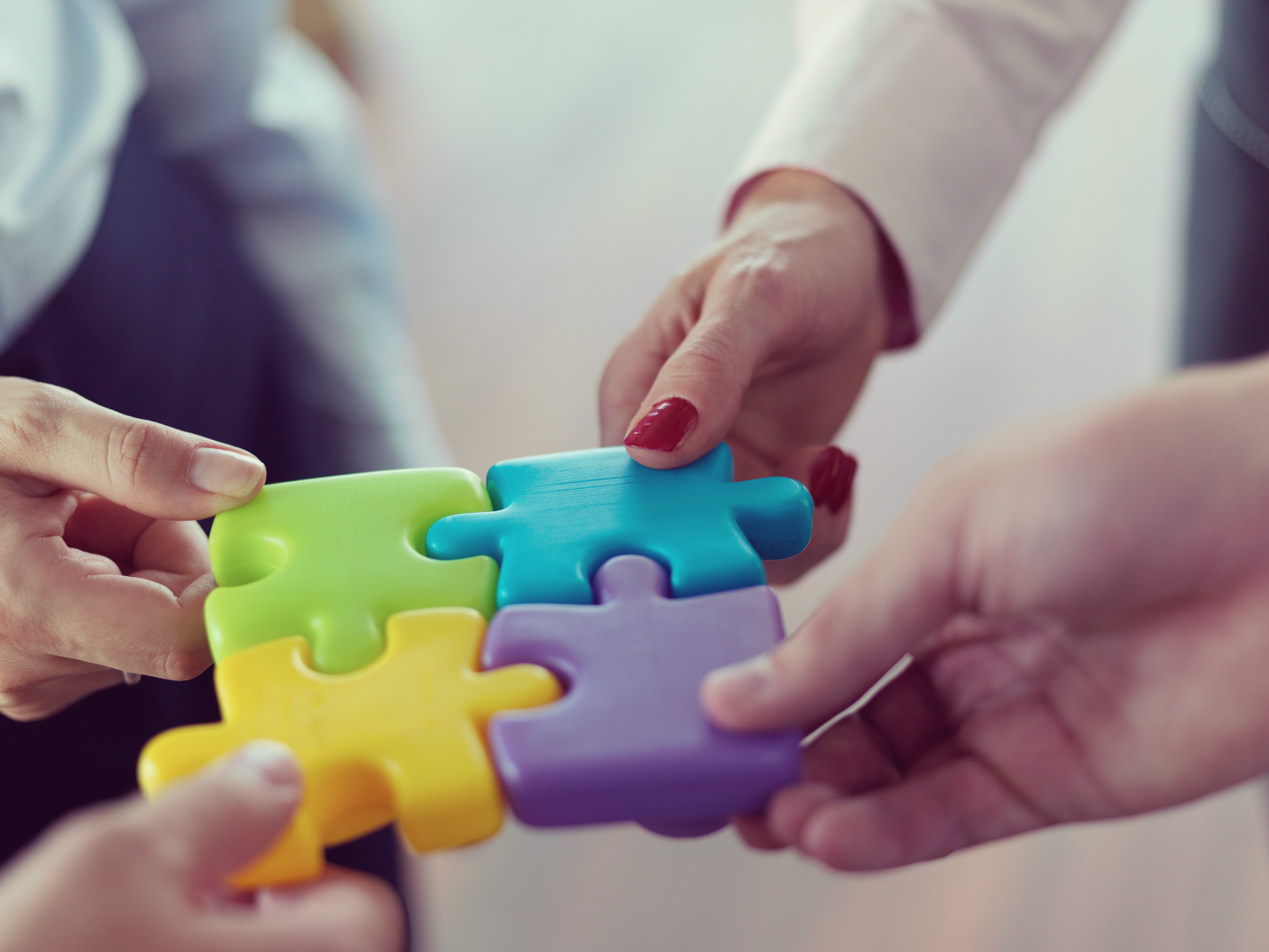 Two people connecting colorful puzzle pieces together